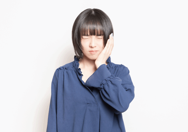 頬を抑える女性